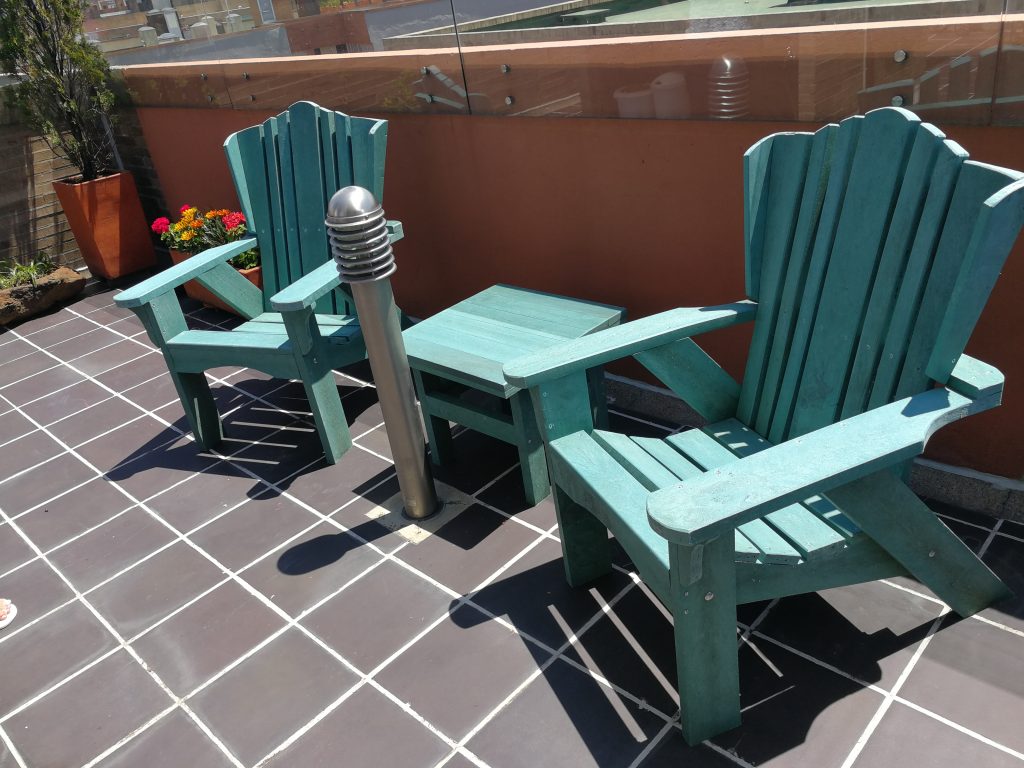 Sillas ecológicas fabricadas con madera plástica reciclada en una terraza, diseño de Ecológica Diseño Sostenible.